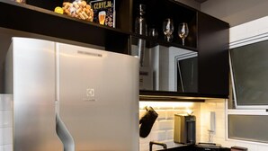 A modern kitchen with a stainless steel refrigerator, black cabinets, a black countertop, and a patterned floor. - 5 Minutes From Copacabana Beach Nsc902 (Rio de Janeiro)