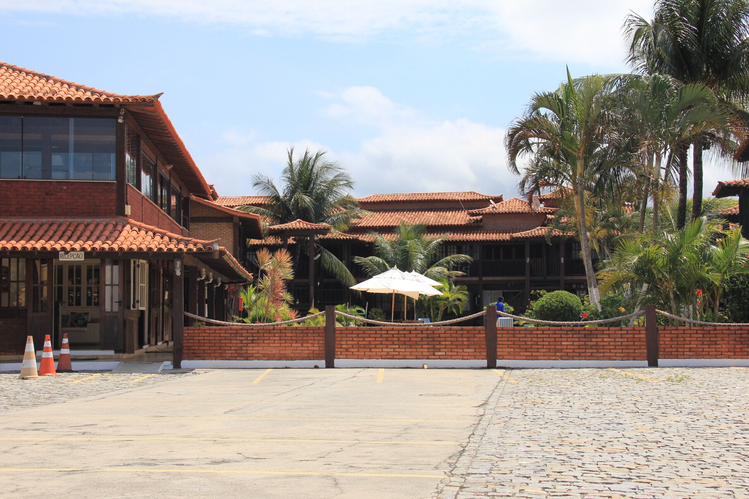 A traditional building with a tiled roof, a brick wall, and a paved courtyard.