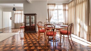 Un comedor con una mesa redonda, sillas de madera y un suelo con patrón de espiga.
