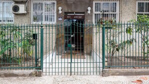 Entrada de um edifício com um portão de metal, uma placa indicando 