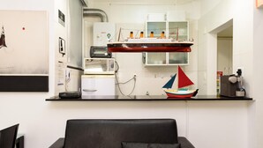 Uma cozinha moderna com um modelo de navio vermelho, um pequeno modelo de veleiro e um micro-ondas.