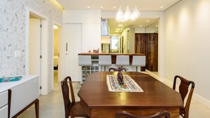 A dining area with a wooden table, chairs, and a decorative centerpiece. - 2 Minutes From Copacabana Beach Nsc601 (Rio de Janeiro)