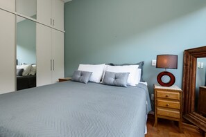 A bedroom with a bed, pillows, a nightstand, a lamp, and a wardrobe. - Peace in Copacabana Forest View Br1009 (Rio de Janeiro)