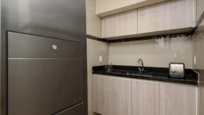 A modern kitchen with a stainless steel refrigerator, a black countertop, a sink, and wooden cabinets. - 800m From Copacabana Beach Bc101 (Rio de Janeiro)