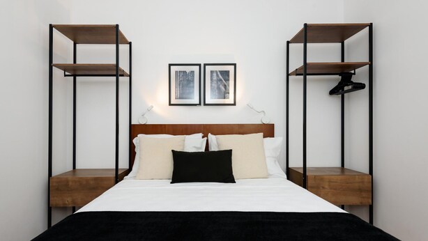 A bedroom with a bed, two wooden nightstands, and two wall-mounted shelves. - 6 Minutes From Ipanema Beach Gc707 (Rio de Janeiro)