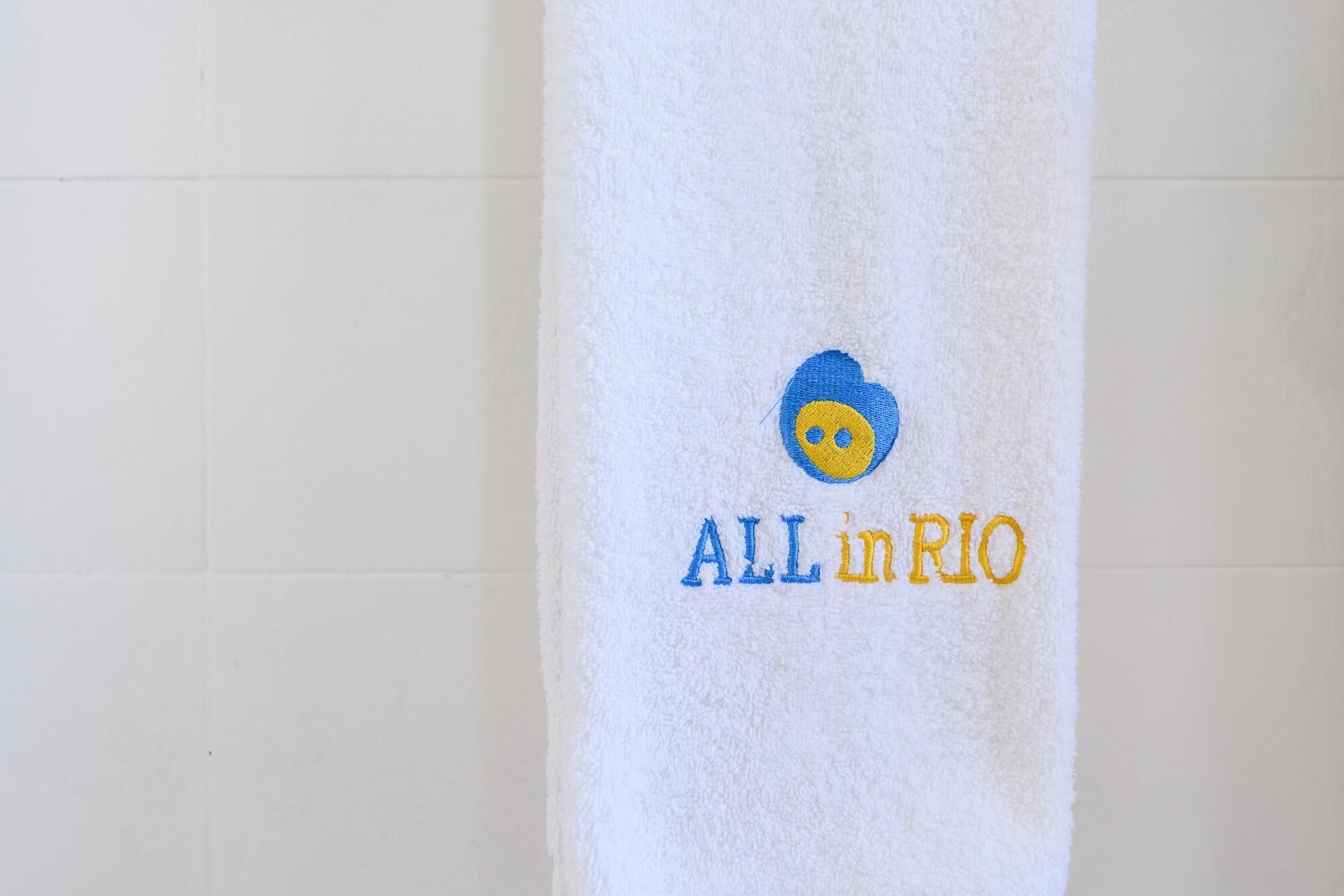 A towel with embroidered text and a logo.