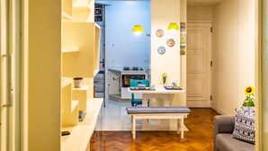 A compact kitchen with a dining area, a bench, and a sofa.