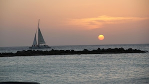 Een zeilboot op rustig water tijdens de zonsondergang.