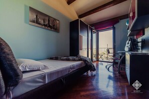 A bedroom with a bed, a desk, and a chair. There is a window with a view of the outside. - Villa Clara - Country Retreat (Solarino)