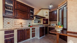 Una cocina con armarios de madera oscura, un salpicadero de azulejos y una isla de madera.
