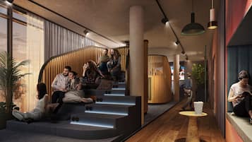 Ein modernes Interieur mit einer geschwungenen Treppe, Holzakzenten und einer Sitzecke mit Personen.