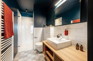 A modern bathroom with a white sink, a mirror, and a shower. - ipartment Braunschweig @HOME by Best Western (Braunschweig)