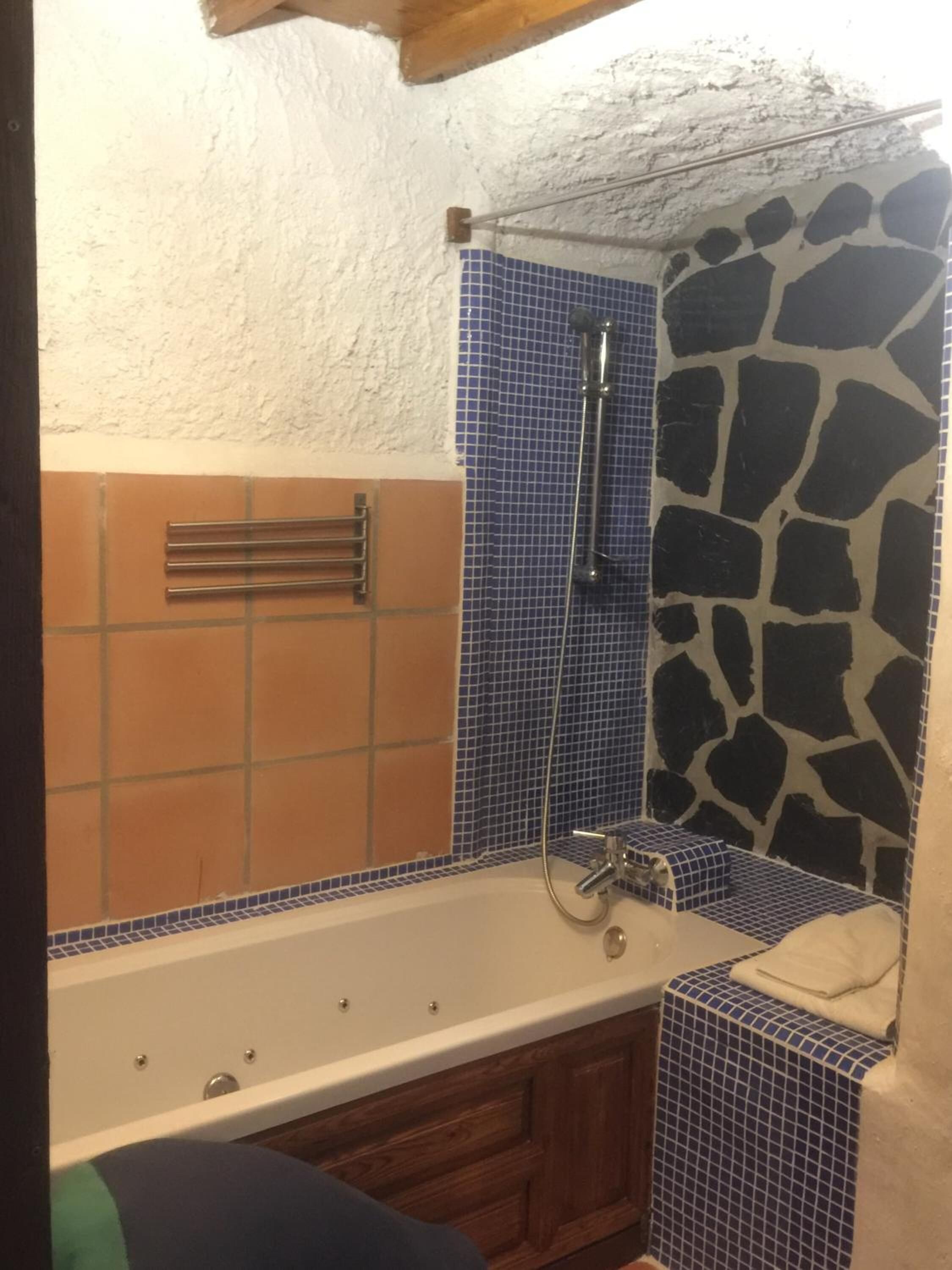 Un baño con bañera, ducha y un mueble de madera.