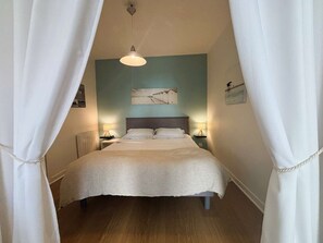 A bedroom with a bed, two bedside lamps, a ceiling light, and a wall-mounted picture. - Bénodet, 3 stars apartment, beach, thalassotherapy and shops on foot (BENODET)