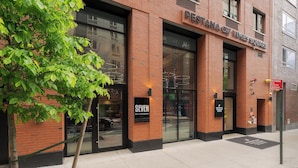A brick building with large windows and a sign for 'Pestana City Times Square'. - Pestana CR7 Times Square (New York)