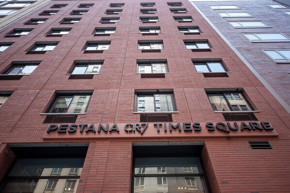 A red brick building with multiple windows and a sign reading "PESTANA CR7 TIMES SQUARE". - Pestana CR7 Times Square (New York)