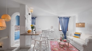 A compact living space with a dining area, a sofa, and a kitchen visible through an archway. - Villa Cissa Apartments by Irundo (Rovinj)