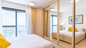 Une chambre d’hôtel avec un grand lit, une armoire et un miroir.