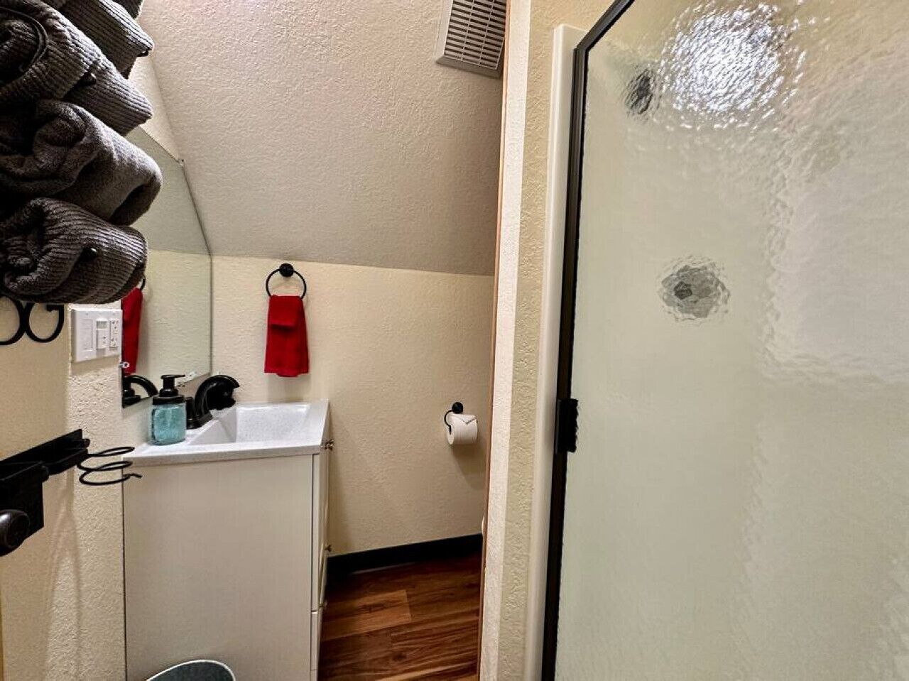 A bathroom with a sink, mirror, and towel rack.