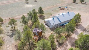 Vue aérienne d’une propriété comprenant un grand bâtiment et un petit chalet.