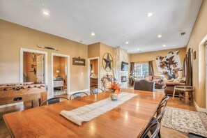 A dining area with a wooden table, chairs, and a foosball table. - 3BD |Cowboy Quarters Retreat Experience (Larkspur)