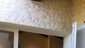 Una habitación con una cama, una mesita de noche con una lámpara y una silla.