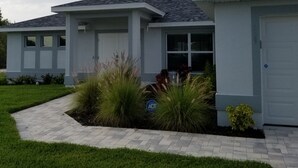 A modern two-story house with a grey exterior, a front garage, and a well-maintained lawn. -  Cape Coral FL Escape! 4Bd, Private pool, waterfront view! Close to beaches



 (Cape Coral)