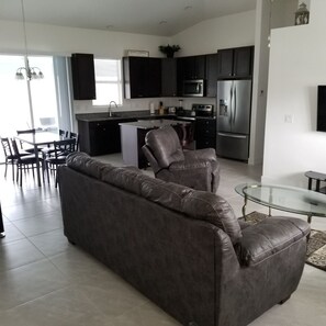 Relax in this stylish living space with a sofa, dining area, and fully equipped kitchen.