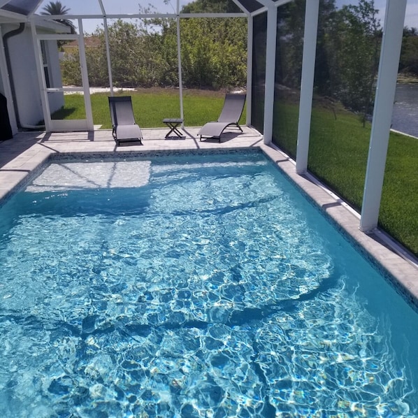 Relax by the pool surrounded by a serene pergola and lush lawn.