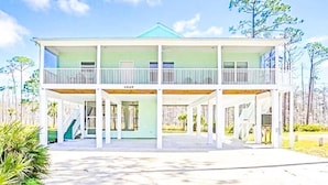 A two-story house with a balcony, a covered porch, and a staircase leading to the upper level.