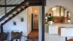 A modern interior with a staircase, a dining area, and a kitchen.