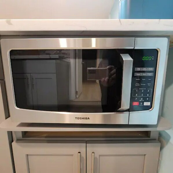 A stainless steel Toshiba microwave oven with a digital display and control panel, placed on a white cabinet. - Private Oasis, Near San Francisco/Oakland 22411 (Hayward)
