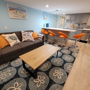 A living room with a sofa, a coffee table, and a patterned rug.