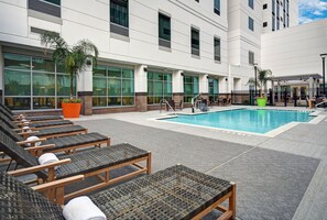 A poolside area with lounge chairs and a swimming pool. - Home2 Suites by Hilton Houston Medical Center, TX (Houston)
