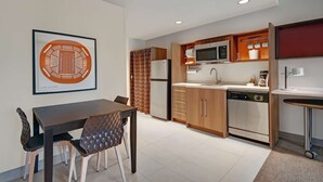 A modern kitchen with a dining area, featuring a microwave, oven, and dishwasher. - Home2 Suites by Hilton Blacksburg - University (Blacksburg)