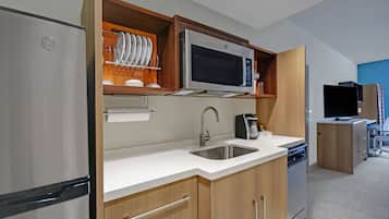 Una cocina moderna con un refrigerador de acero inoxidable, un microondas y un lavavajillas.