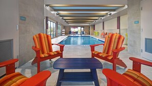 A pool area with chairs and a table, a view of the pool, and a sign indicating storage.