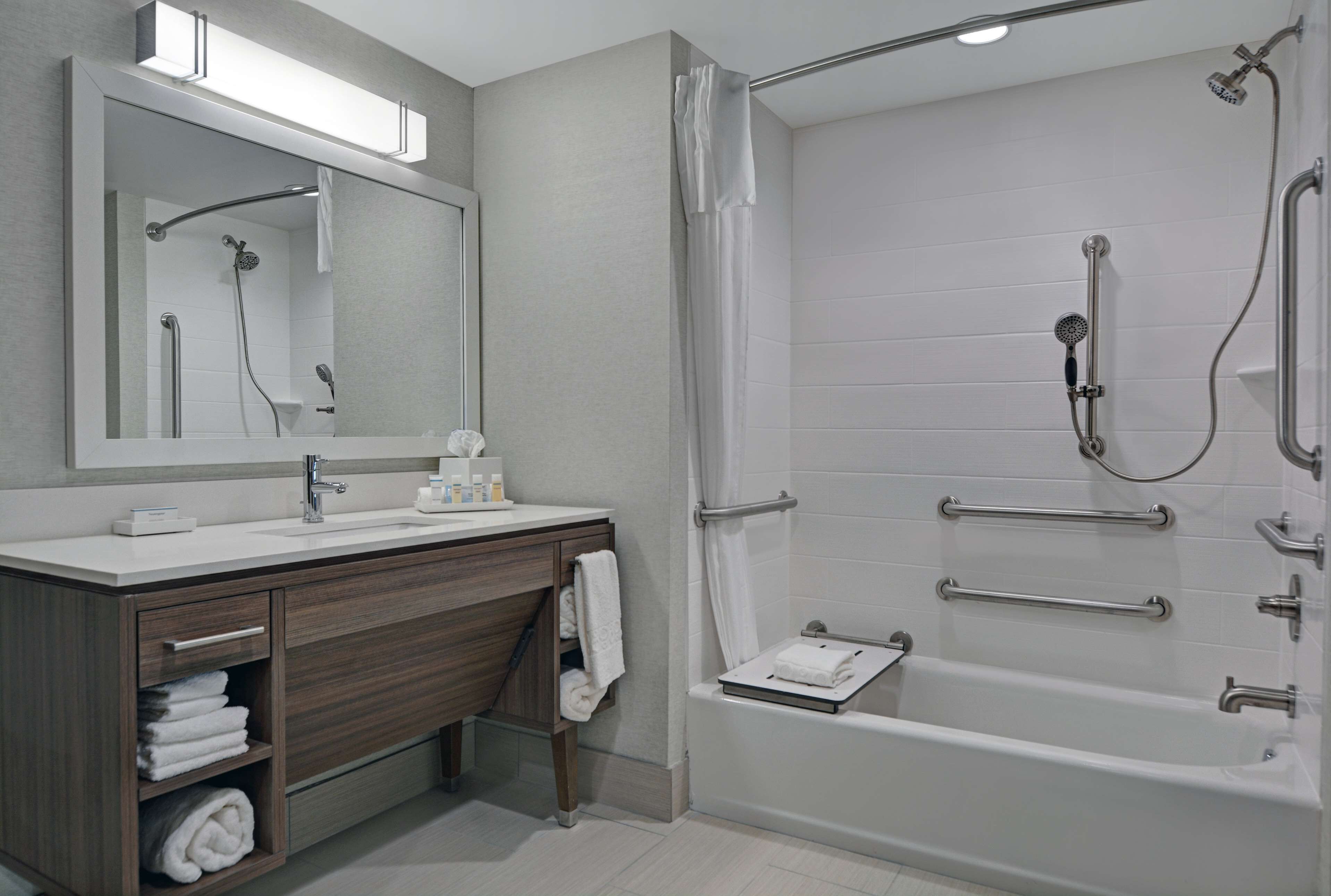 Un baño moderno con ducha, lavabo y tocador.