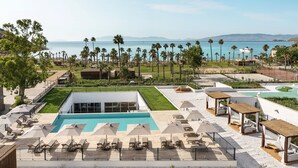 A resort with a swimming pool, lounge chairs, and a view of the sea. - Radisson Collection Hotel Bodrum (Bodrum)