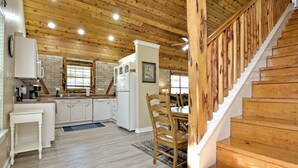 Un intérieur en bois comprenant une cuisine, un coin repas et un escalier.