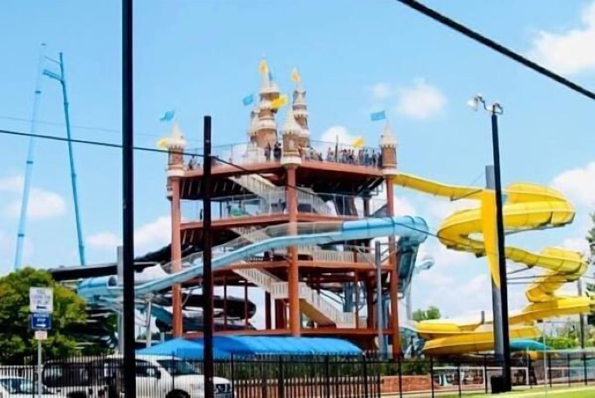 Una estructura de parque acuático de varios niveles con diversas toboganes y una torre central.