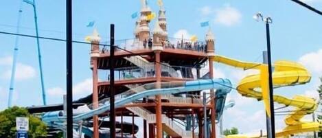 Una estructura de parque acuático de varios niveles con diversas toboganes y una torre central.