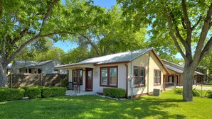 A single-story house with a front porch, a covered patio, and a well-maintained lawn.