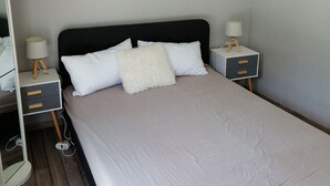 A neatly made bed with white bedding and two bedside tables with lamps. - Charming independent studio in Martigues town center, swimming pool, spa (Martigues)