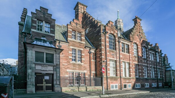 A historic building with a prominent clock tower, large windows, and a traditional brick facade. - Old Town Gem - Castle, Dark History, Uni (Edinburgh)