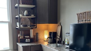 A kitchen with a built-in stove, a refrigerator, and a shelf unit. - Cozy and artistic Pied-a-Terre, perfect for a weekend romantic getaway. (Little Falls)