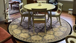 A dining area with a round table, four chairs, a cabinet with glass doors, a window with a view, and a patterned rug. - Cozy and artistic Pied-a-Terre, perfect for a weekend romantic getaway. (Little Falls)