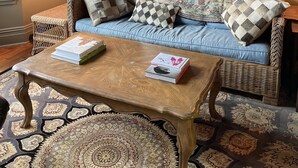 A cozy living room with a blue sofa, patterned cushions, a wooden coffee table, and a large mirror wall. - Cozy and artistic Pied-a-Terre, perfect for a weekend romantic getaway. (Little Falls)