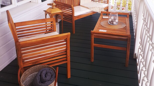 A wooden porch with a bench, a table, and a basket. - LA BELLE BLANCHE MAISON VUE DU FLEUVE, PRÈS DE MÉTIS SUR MER (Saint-Ulric)