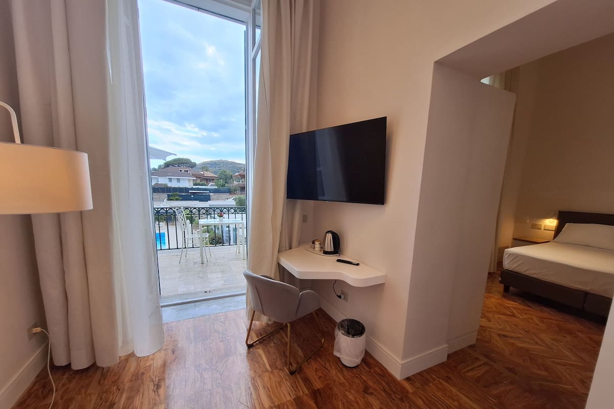 Suite, terrazzo, vista mare parziale | Area soggiorno | TV a schermo piatto 32 pollici con canali digitali, TV